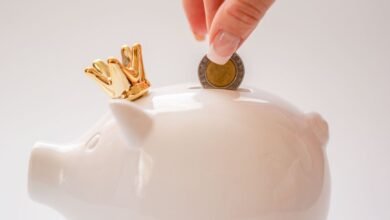 hand putting coins into a piggy bank