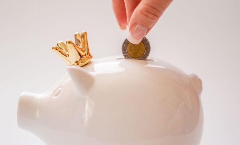 hand putting coins into a piggy bank