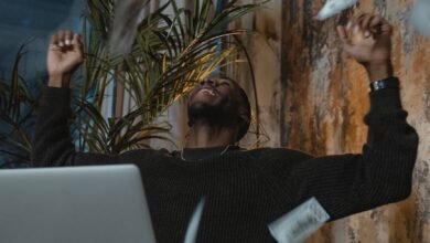 a man in a sweater celebrating with money in the air