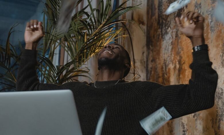 a man in a sweater celebrating with money in the air