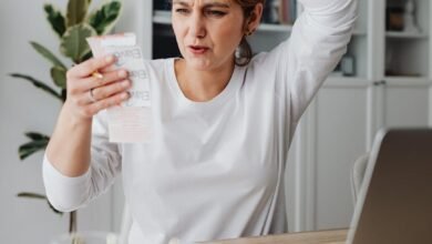 woman looking at a receipt and making a surprised face