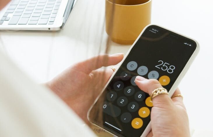 a person calculating on her cellphone
