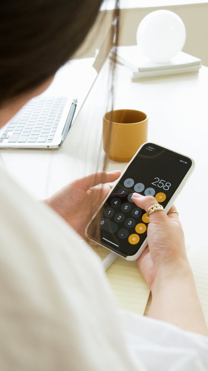 a person calculating on her cellphone