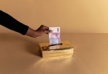 person putting money inside the gold box