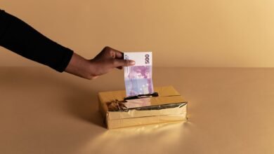 person putting money inside the gold box