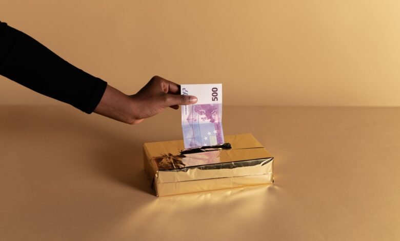 person putting money inside the gold box