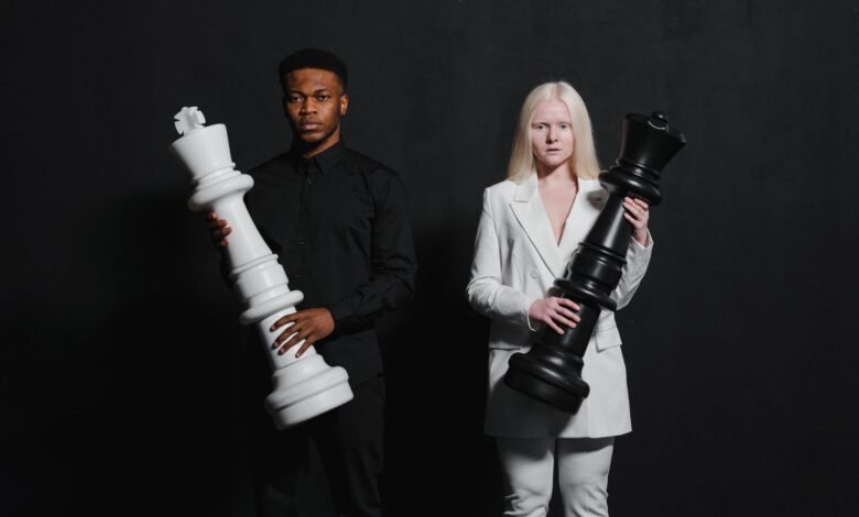 man and woman standing while holding chess pieces