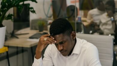 man in white long sleeves shirt sitting behind his desk