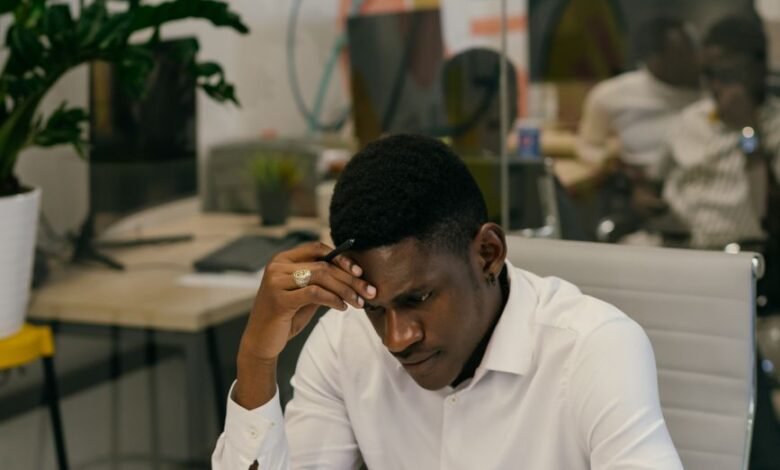 man in white long sleeves shirt sitting behind his desk