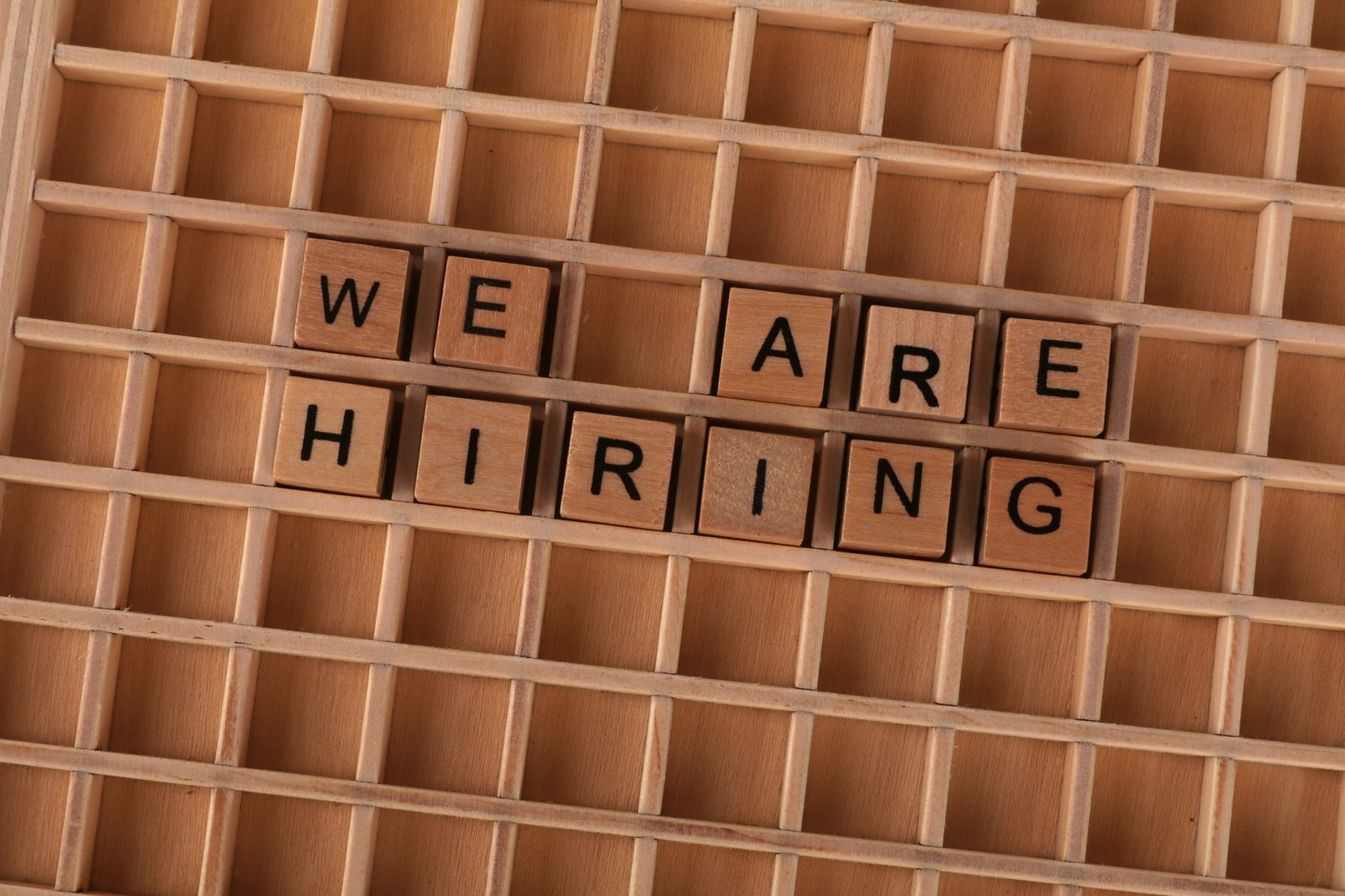 wooden tile letters spelling we are hiring